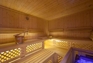 an empty wooden sauna with a bucket in it at Sporthotel Kalcherhof in Racines