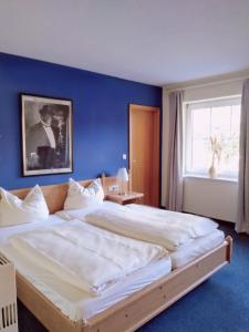 a bedroom with a large bed with a blue wall at Excellent Hotel Hamburg in Hamburg