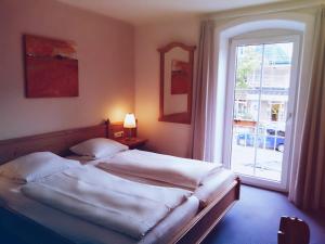 a bedroom with a bed and a large window at Excellent Hotel Hamburg in Hamburg