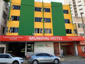 Mundial Hotel في غويانيا: سيارتين متوقفتين أمام مبنى كبير