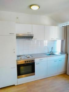a white kitchen with a stove and a sink at Excellent Hotel Hamburg in Hamburg