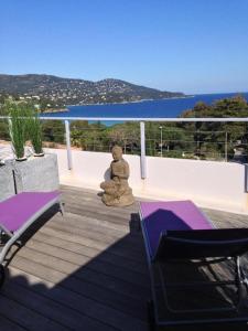 a teddy bear statue sitting on the deck of a house at Residence Le Mas in Le Lavandou