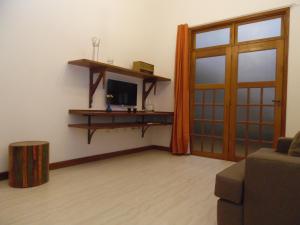 uma sala de estar com uma porta e uma televisão em Flat aconchegante no Centro Histórico em São João del Rei