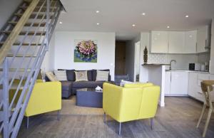 a living room with yellow chairs and a couch at Residence Le Mas in Le Lavandou