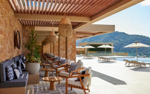 a patio with chairs and tables and a pool at Elix, Mar-Bella Collection in Perdika