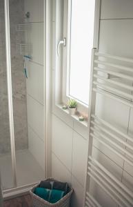 biała łazienka z prysznicem i oknem w obiekcie Haus Karli w mieście Nordhausen