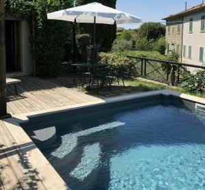 een zwembad met een tafel en een parasol bij Villa Toppani Del Sodo in Cortona