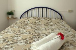un letto con una coperta con un fiore rosso sopra di Nettuno 1A a Lido di Pomposa
