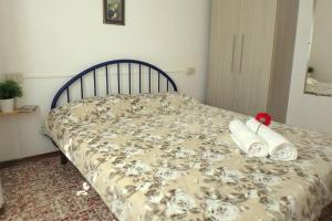 un letto con asciugamani e un fiore sopra di Nettuno 1A a Lido di Pomposa Altre 19 foto