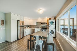 a kitchen with a wooden table and a kitchen with appliances at Heron House on the Cove in Coupeville