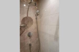 a shower with a shower head in a bathroom at Луксозен апартамент с WiFi на 10км от Боровец in Samokov