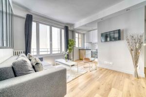 uma sala de estar com um sofá e uma cozinha em 1628 - Loft Champs Elysées Olympic Games 2024 em Paris