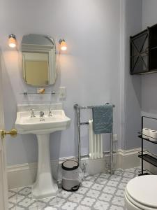 a white bathroom with a sink and a mirror at The Westgate in Charmouth
