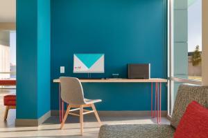 a room with a blue chair and a blue wall at avid hotels - Boston Logan Airport - Revere, an IHG Hotel in Revere