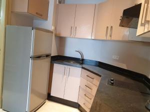 拉巴特的住宿－Residence Davos Rabat，厨房配有白色橱柜和冰箱。