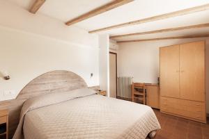 1 dormitorio con 1 cama grande y armario de madera en Hotel Pini, en Corniolo