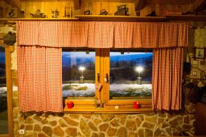 a window with a red and white checkered curtain at Kuća za odmor Gloria in Travnik