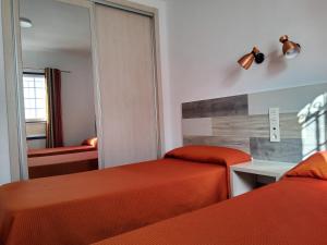 een hotelkamer met twee bedden en een spiegel bij Atlantis Las Lomas in Puerto del Carmen +14 foto's