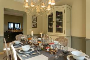 a dining room with a table with a chandelier at Riverside Cottage Dinant in Dinant