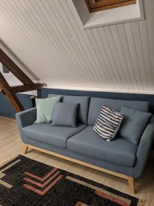 ein blaues Sofa in einem Zimmer mit einer Decke in der Unterkunft Numéro 7 in Le Tronquay