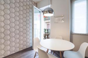 una sala da pranzo con tavolo e sedie bianchi di Contempora Apartments - Cavallotti 13 - A61 a Milano