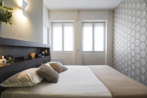una camera con un grande letto e due finestre di Contempora Apartments - Cavallotti 13 - A61 a Milano