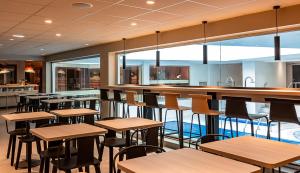 an empty restaurant with tables and a bar at Oceania Paris Porte De Versailles in Paris