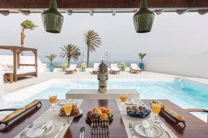 a dining table with a bowl of fruit next to a swimming pool at Villa Atlantis I in La Asomada