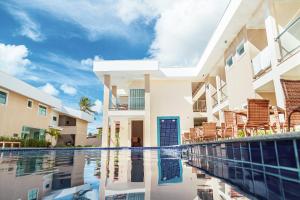 a swimming pool in front of a building at Orquídeas Praia Hotel in Porto Seguro