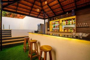 a bar with two stools and a counter with drinks at De Lagom Comforts, Anjuna Beach in Anjuna