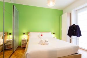 1 dormitorio con 1 cama blanca y paredes verdes en FieraMI CityLife, en Milán