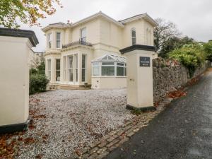 a large white house with a stone wall at Holcombe House in Torquay