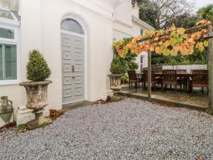 a white house with an arbor and a dining table at Holcombe House in Torquay