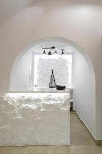 
a white bed sitting in a room next to a wall at Saint George Hotel in Naxos Chora

