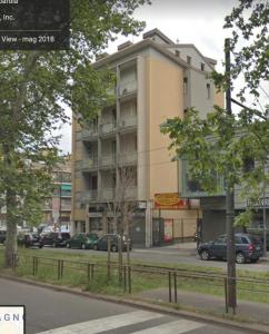 a building with cars parked in front of a street at Dimora Certosa - Milano in Milan