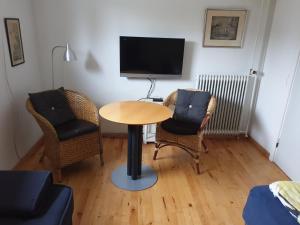 a room with a table and two chairs and a tv at Underetage i Dronningborgvilla in Randers