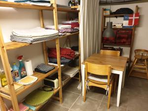 Zimmer mit einem Schreibtisch, einem Tisch, einem Tisch und Regalen in der Unterkunft Underetage i Dronningborgvilla in Randers