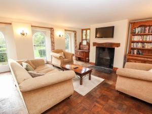 sala de estar con 2 sofás y chimenea en Abbey Cottage, en Denbigh