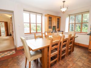une salle à manger avec une table et des chaises en bois dans l'établissement Abbey Cottage, à Denbigh