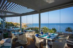 a restaurant with tables and chairs and a view of the ocean at InterContinental Cascais-Estoril by IHG in Estoril
