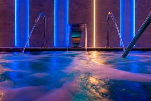 a hot tub in a room with blue lights at L'Azure Hotel 4* Sup in Lloret de Mar