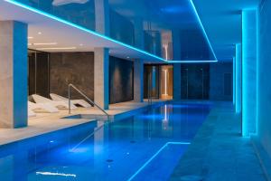 a swimming pool in a building with blue lighting at L'Azure Hotel 4* Sup in Lloret de Mar