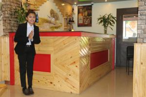 a woman in a suit standing in front of a counter at Hotel Happy Home in Chitwan