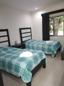 2 Betten nebeneinander in einem Zimmer in der Unterkunft Hotel Sevilla Palenque in Palenque
