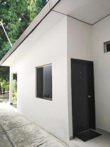 a white building with a black door on it at Hotel Sevilla Palenque in Palenque