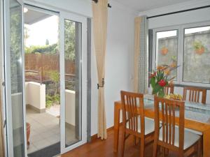 a dining room with a table and a glass door at Garden's Apartment in Funchal