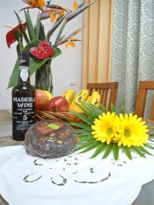 a table with a bottle of wine and a bouquet of flowers at Garden's Apartment in Funchal