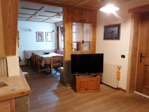 een woonkamer met een televisie en een tafel bij Taverna Larice in Valdidentro