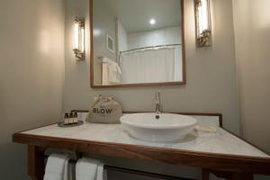 a white sink sitting under a mirror in a bathroom at Hotel G San Francisco in San Francisco