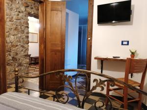 a room with a bed and a table and a television at Deiana affittacamere e pizzeria in Santu Lussurgiu